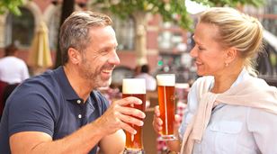 Pariskunta kohottaa täysiä oluttuoppeja Hampurissa