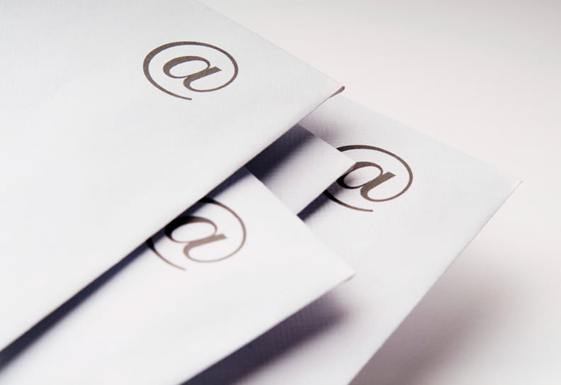 Neljä valkoista kirjekuorta, joissa @ -merkki