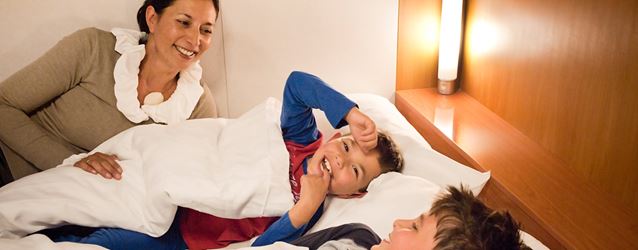 Äiti yrittää nukuttaa pikkupoikia hytissä lauttamatkalla Irlantiin mutta poikia vaan naurattaa